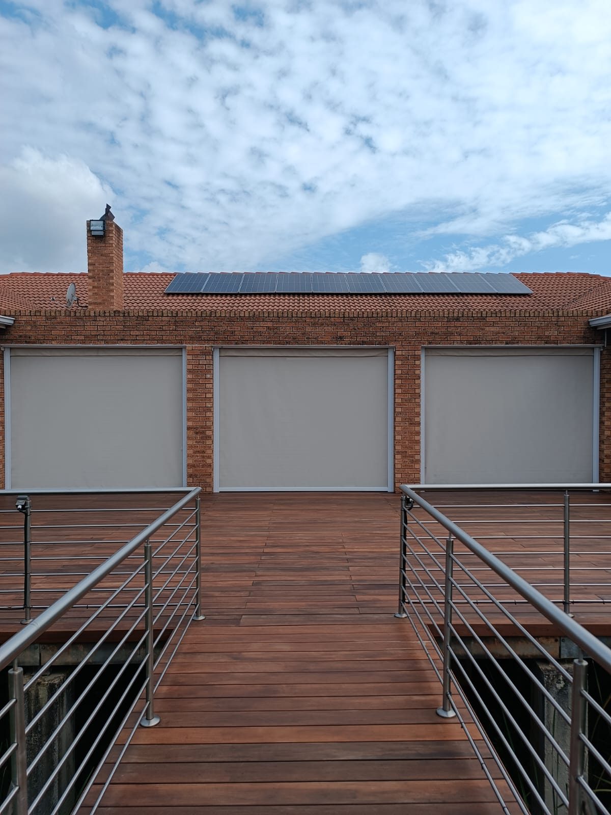 Outdoor roller screens on a brick patio deck