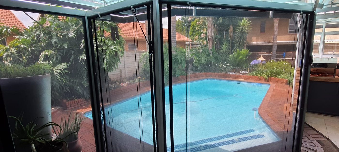 Outdoor sheerweave blinds overlooking a pool patio