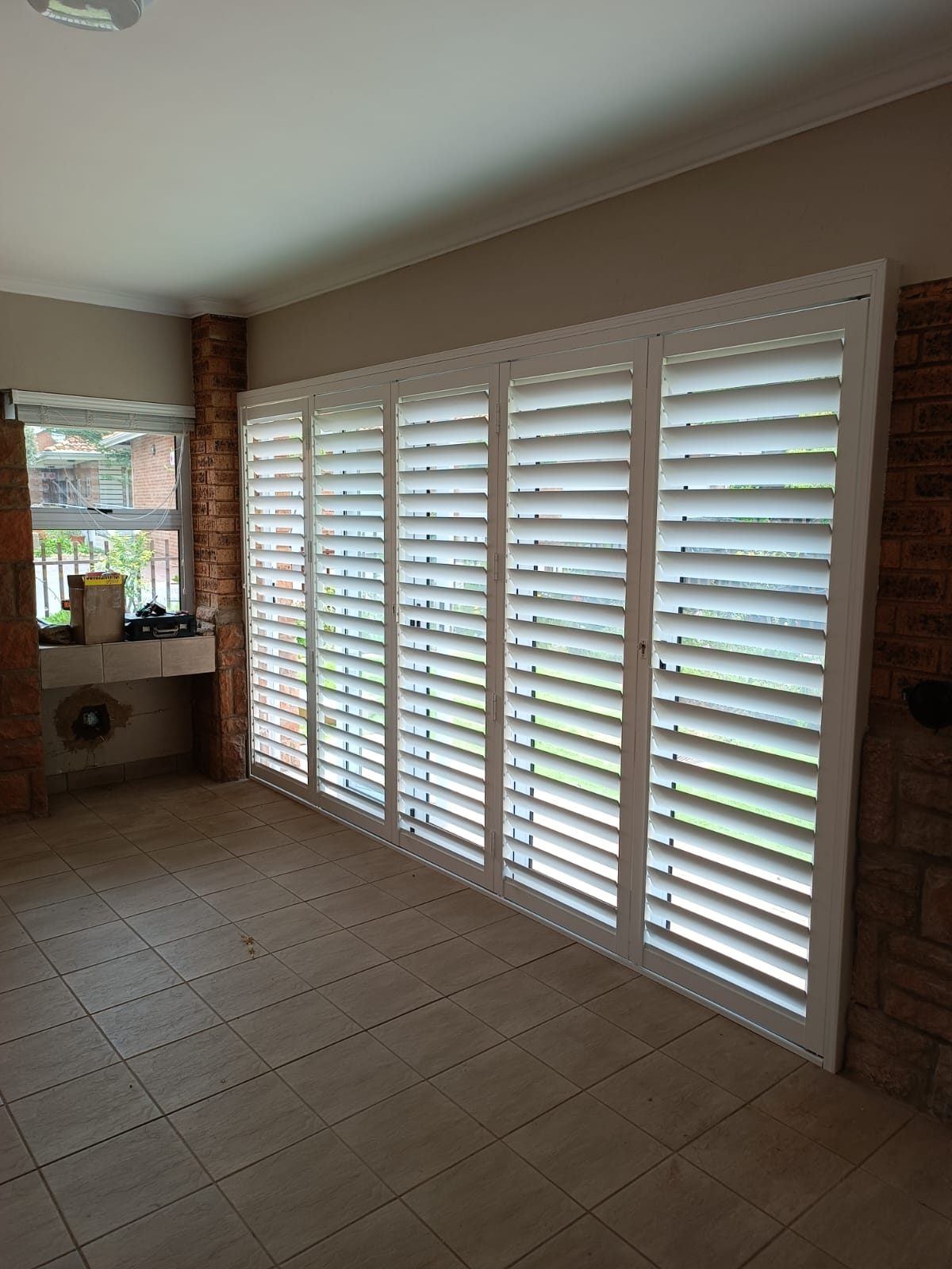 White plantation shutters on a wide opening