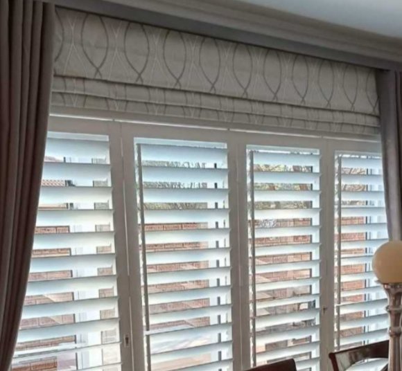 Close view of white plantation shutter panels from a We Do Blinds dining-room install.